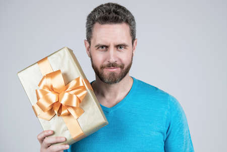 handsome mature man businessman with beard holding present or gift box, anniversaryの写真素材