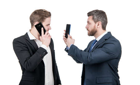 negotiation disagreement of talking man on smartphone and businessman showing phone, argue.の写真素材