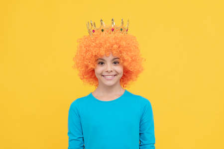 girls birthday party. happy funny kid in curly wig and crown. imagine herself a queen.の写真素材