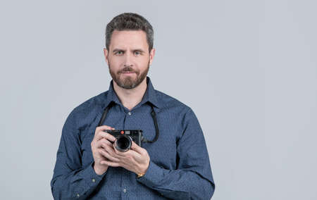 Bearded man hold photo camera. Photographic equipment. Photographic studio, copy spaceの写真素材