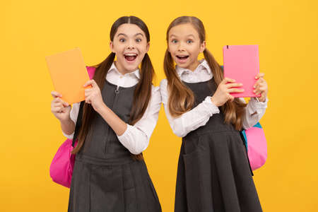 Read me story. Surprised kids hold books yellow background. Childrens literature. Literature lessonの写真素材