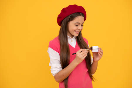 happy teen girl in french beret apply blush with powder bwush, blushの写真素材