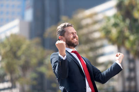happy man businessman in suit and red tie celebrating business success express happiness, successの写真素材