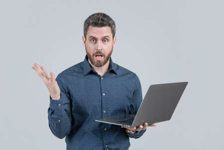 amazed handsome mature man businessman with beard working online on laptop, business problem