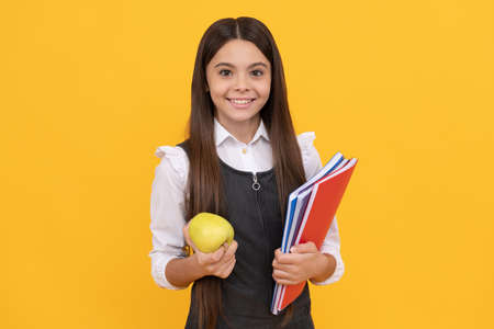 Lets start to learn for a better future. Happy kid smile holding apple and books. Learn todayの写真素材