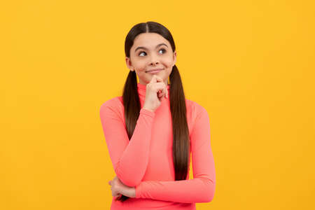 dreaming child with long hair on yellow background, daydreamerの写真素材