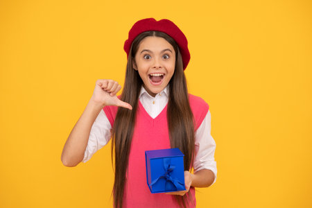 purchase a gift. happy french teen girl presenting present box. childhood happiness.の写真素材