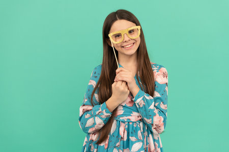 Keep smiling. Happy child smile holding prop glasses. Happy childhood and girlhoodの写真素材