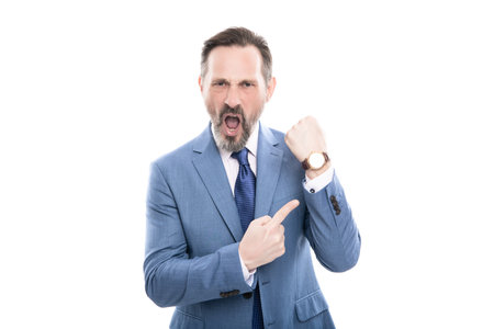 angry mature director in suit pointing finger on time on watch isolated on white, late.の写真素材