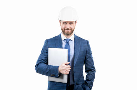 confident businessman man in suit and safety helmet hold computer isolated on white, ceoの写真素材