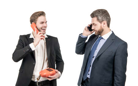 Make the best of what you have. Businessmen use mobile phone and retro phoneの写真素材