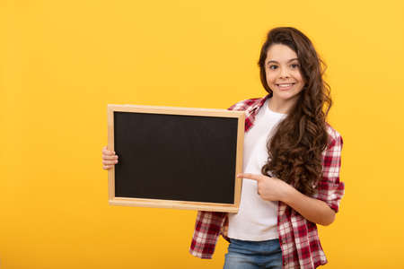 happy kid pointing finger on school blackboard for copy space, educationの写真素材