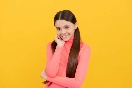 happy kid with long hair on yellow background, fashionの写真素材