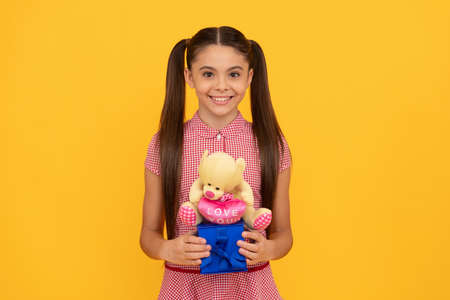 gift box with love. cheerful child with teddy bear. present for holidays. happy birthday.の写真素材