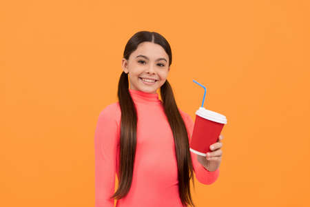 happy kid with takeaway coffee cup on yellow background, good morningの写真素材