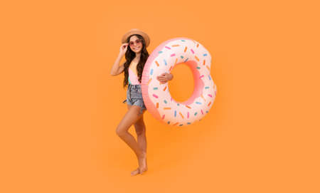 beach teen girl with doughnut inflatable ring for pool party fun on summer vacation, beach accessoryの写真素材