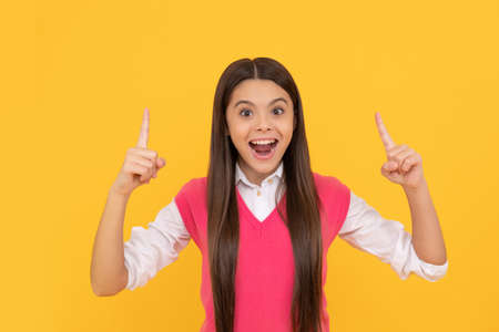 amazed teen school girl with long hair inspired with idea on yellow background, amazementの写真素材