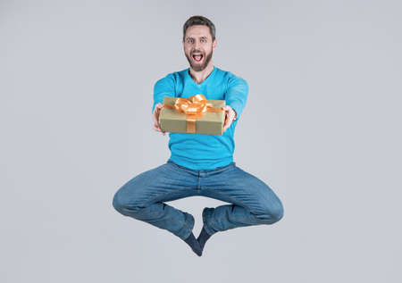energetic happy surprised man giving present or gift box, surpriseの写真素材