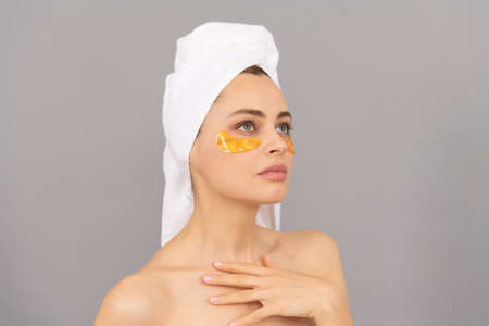 young woman with terry towel use facial golden eye patch for skin, skinの写真素材