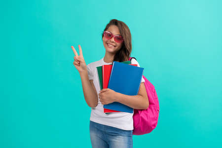 childhood. student child with school bag. high school. peace. happy girl carry backpack and notebookの写真素材