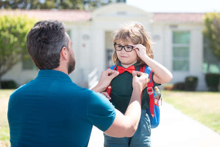 nerd in glasses and bow tie with teacher outside the school, educationの写真素材