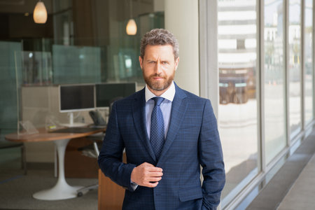mature unshaven man entrepreneur in businesslike suit outside the office, agile businessの写真素材