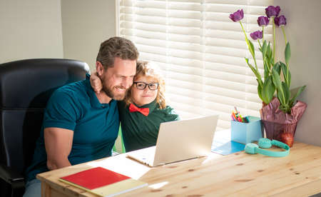 happy daddy or teacher helping his school son kid in glasses study with pc in classroom, educationの写真素材