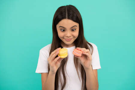 amazed child hold french macaron or macaroon cookies, sweet toothの写真素材