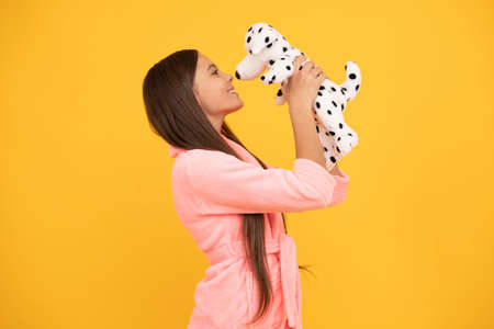 happy teen girl in home terry bathrobe with toy, kissの写真素材