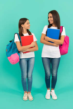 happy teen girl and mother or teacher hold school workbook for studying, schoolの写真素材