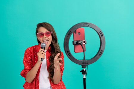 vocal tutorial lesson online. happy teenage girl singer use selfie led. kid music blogger.の写真素材