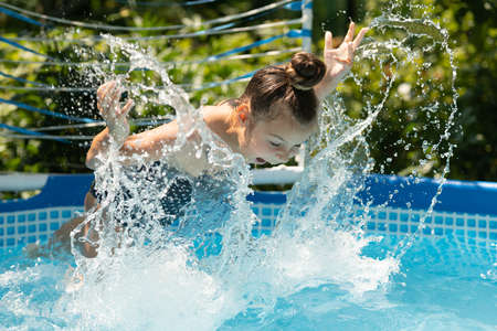 Splisha-splasha. Happy girl swim in swimming pool. Chill pool day. To show off your swimの写真素材