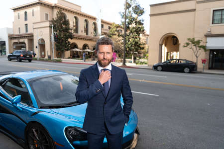 confident business man in businesslike suit rent car standing outdoor in the street, car rentの写真素材