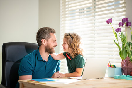 back to school. loving daddy and son in glasses use computer at home. family blog.の写真素材