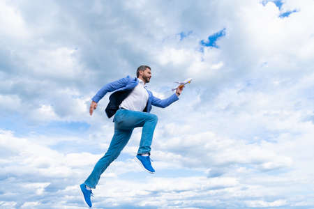 happy man businessperson in jacket hold toy plane on sky background run to success, achievementの写真素材