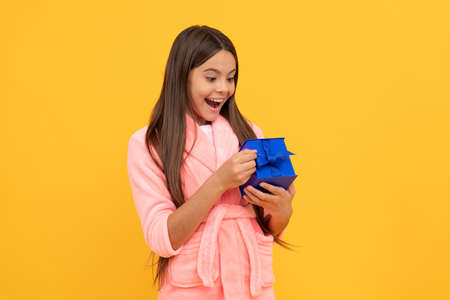 surprised teen girl in home terry bathrobe open gift or present box, surpriseの写真素材