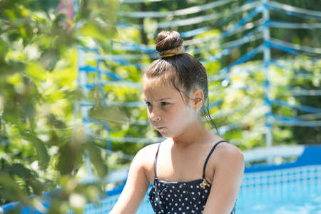 Serious wet child chill in leisure pool on sunny summer day, kidの写真素材