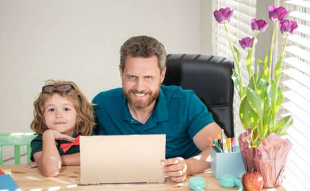 mature man teacher or dad helping kid son with school homework on computer, school