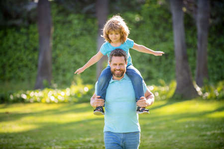 Ill give a piggy-back ride. Happy man carry son sitting on shoulders. Happy kid ride piggy-backの写真素材