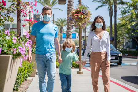 parents with kid boy wear medical mask. mom dad and son. life insurance. adoption and charity.の写真素材
