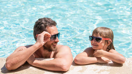 childhood and parenting. friendship. father and son wear glasses in swimming pool waterの写真素材