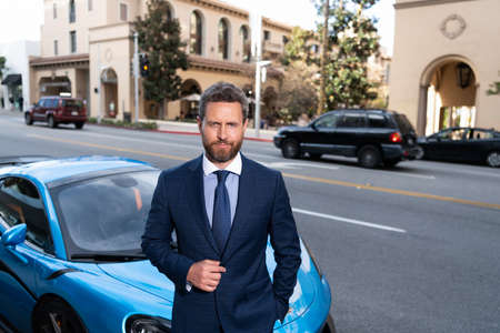 handsome man in expensive suit. confident business executive rent car. boss at luxury automobileの写真素材