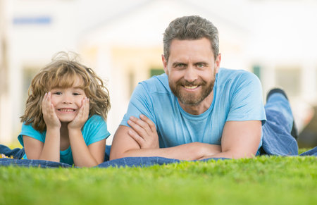 happy father with child relax together on green park grass, familyの写真素材