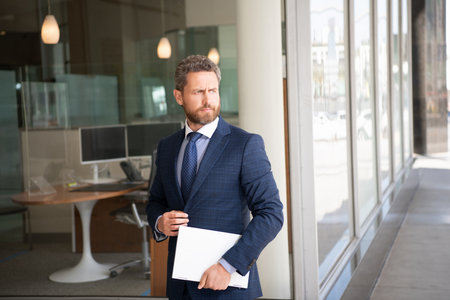 mature businessman near office. agile business success. freelance man use pc.の写真素材