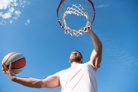 man play basketball outdoor. man jump to throw the ball. guy play basketball.の写真素材