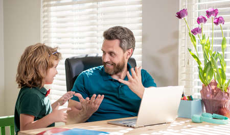 mature man teacher or dad helping kid son with school homework on computer, amazementの写真素材