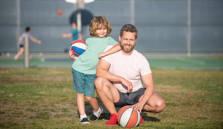 happy father and kid playing basketball with ball outdoor, sportの写真素材
