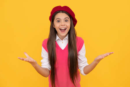 surprised teen school girl in french beret on yellow background, surpriseの写真素材