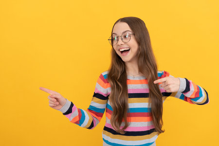 happy smart kid. teen girl in eyeglasses pointing fingers. vision acuity. eyesight.の写真素材