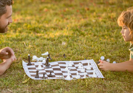 father and son playing chess in park. fathers day. happy family bonding. parenthoodの写真素材